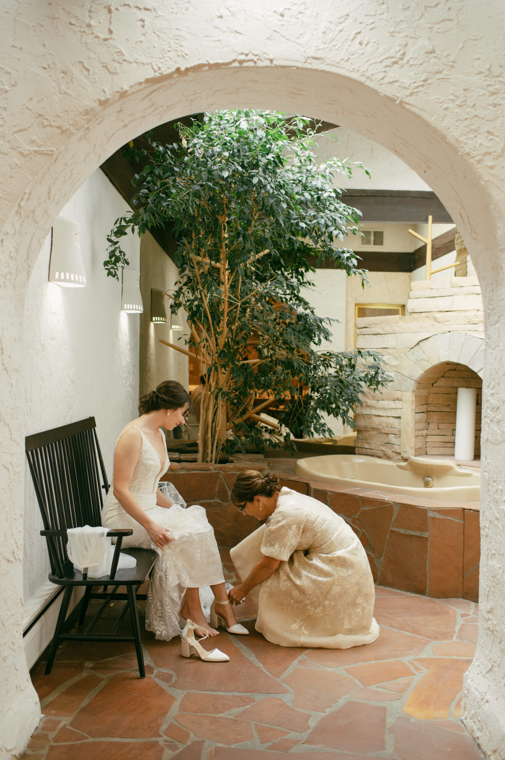 A bride and her mom getting dressed in the grotto at Villa Parker in Denver, Colorado.