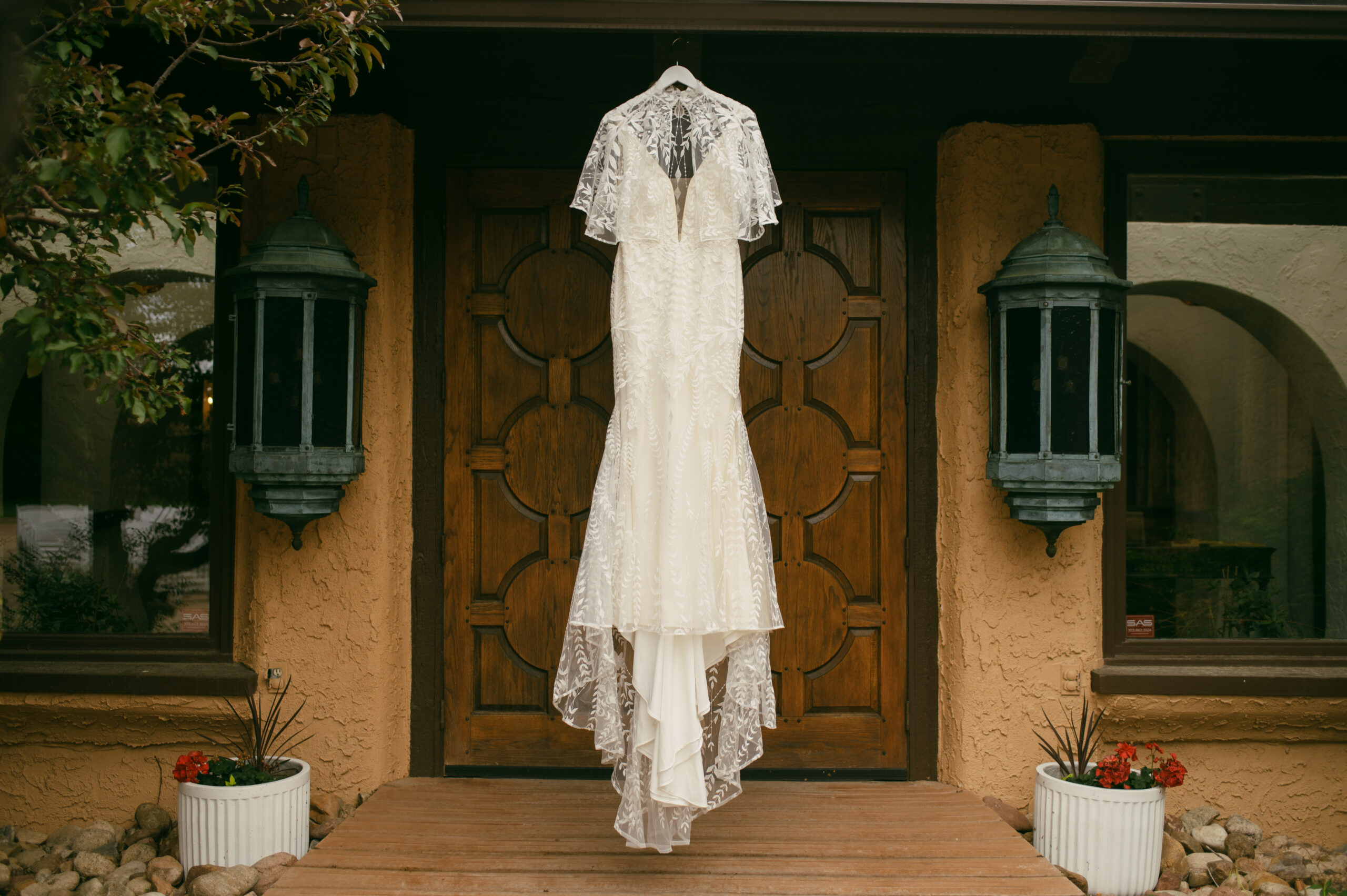 Boho chic wedding dress hangs on the modern door of Villa Parker wedding Venue in Denver, Colorado