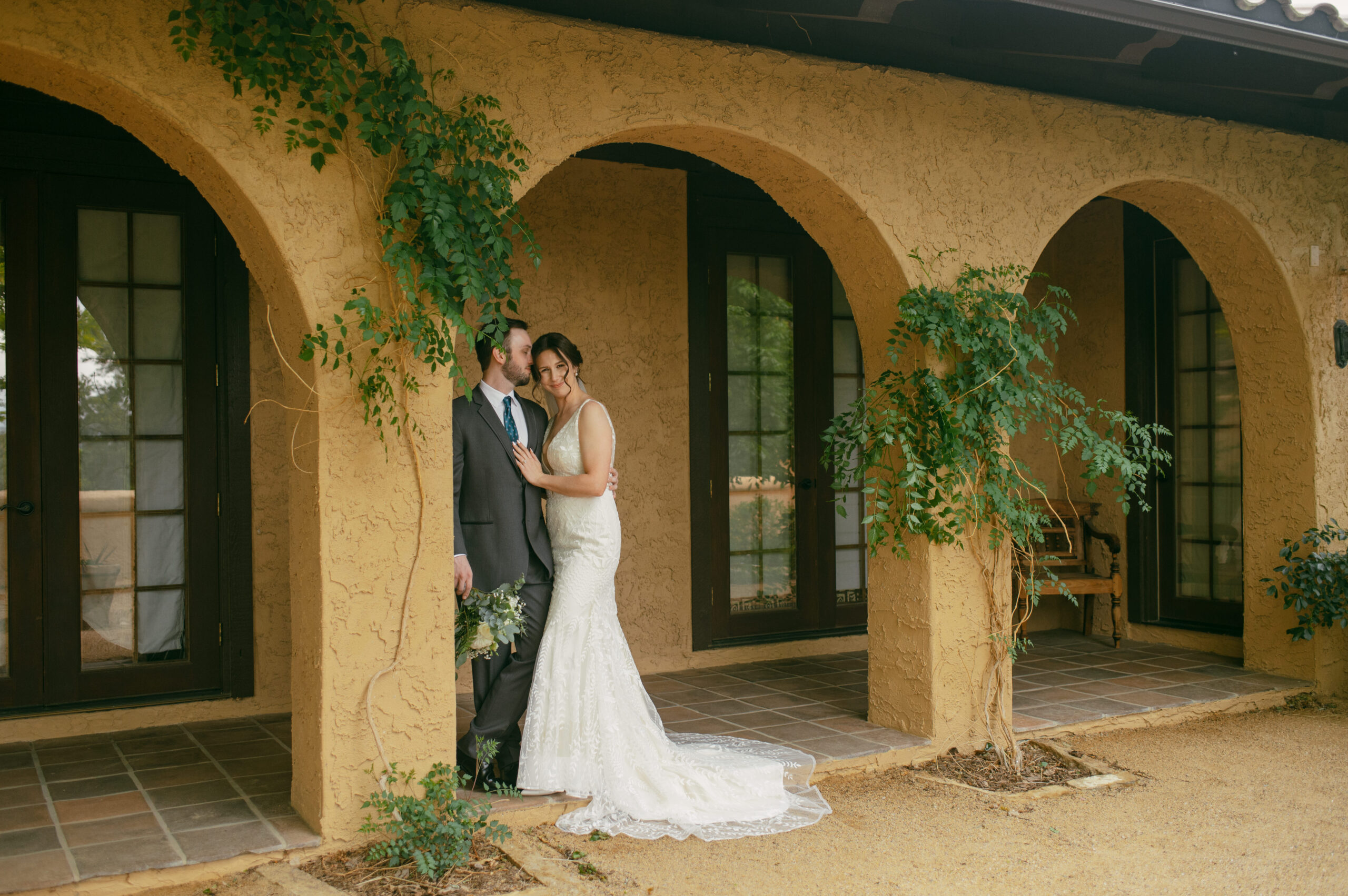 A bride and groom stand under the boho arches of Villa Parker wedding venue in Parker, Colorado.