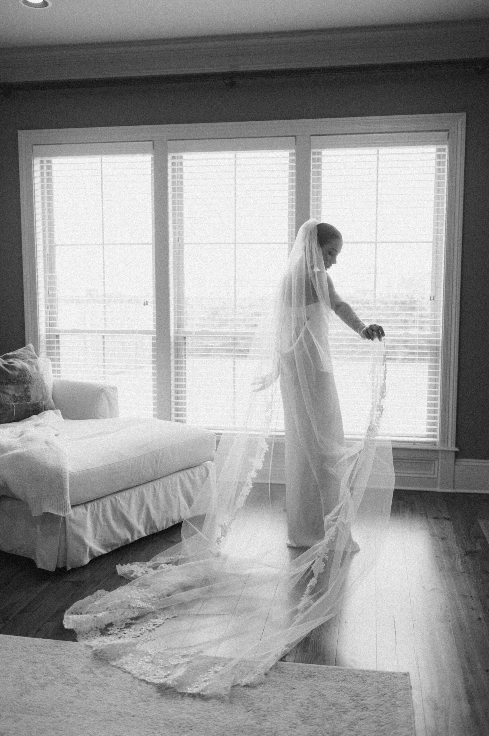 A modern and chic bride with her cathedral veil getting ready at her house.