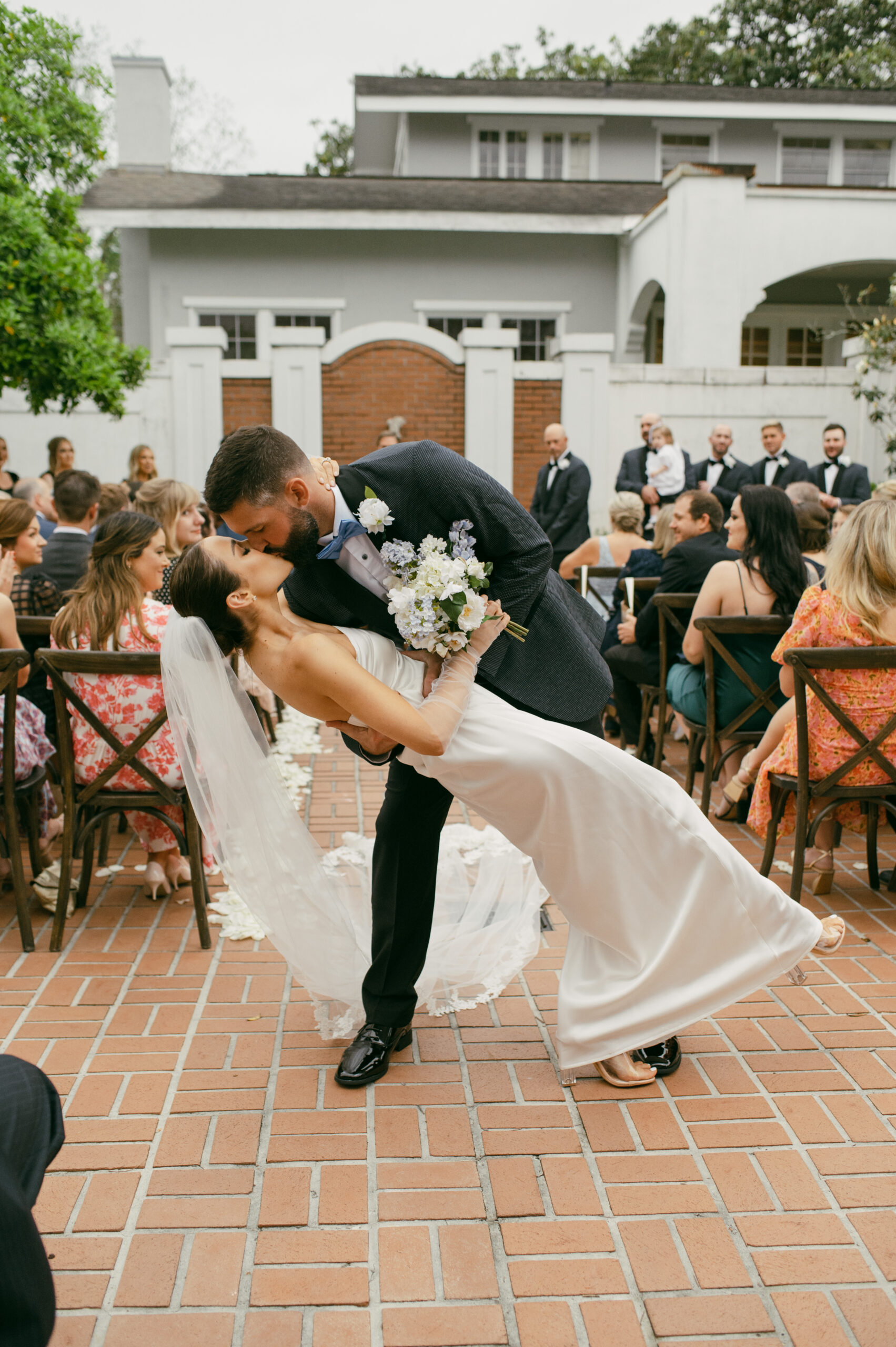 A bride and groom dip-kissing at the end of their ceremony at the Old Governor's Mansion in Baton Rouge, Louisiana.