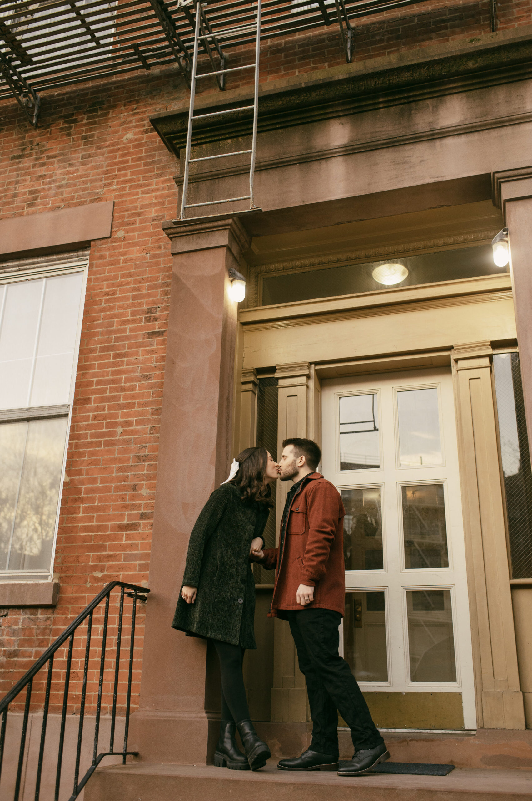 A couple kissing on the steps of their neighborhood in Greenwich Village
