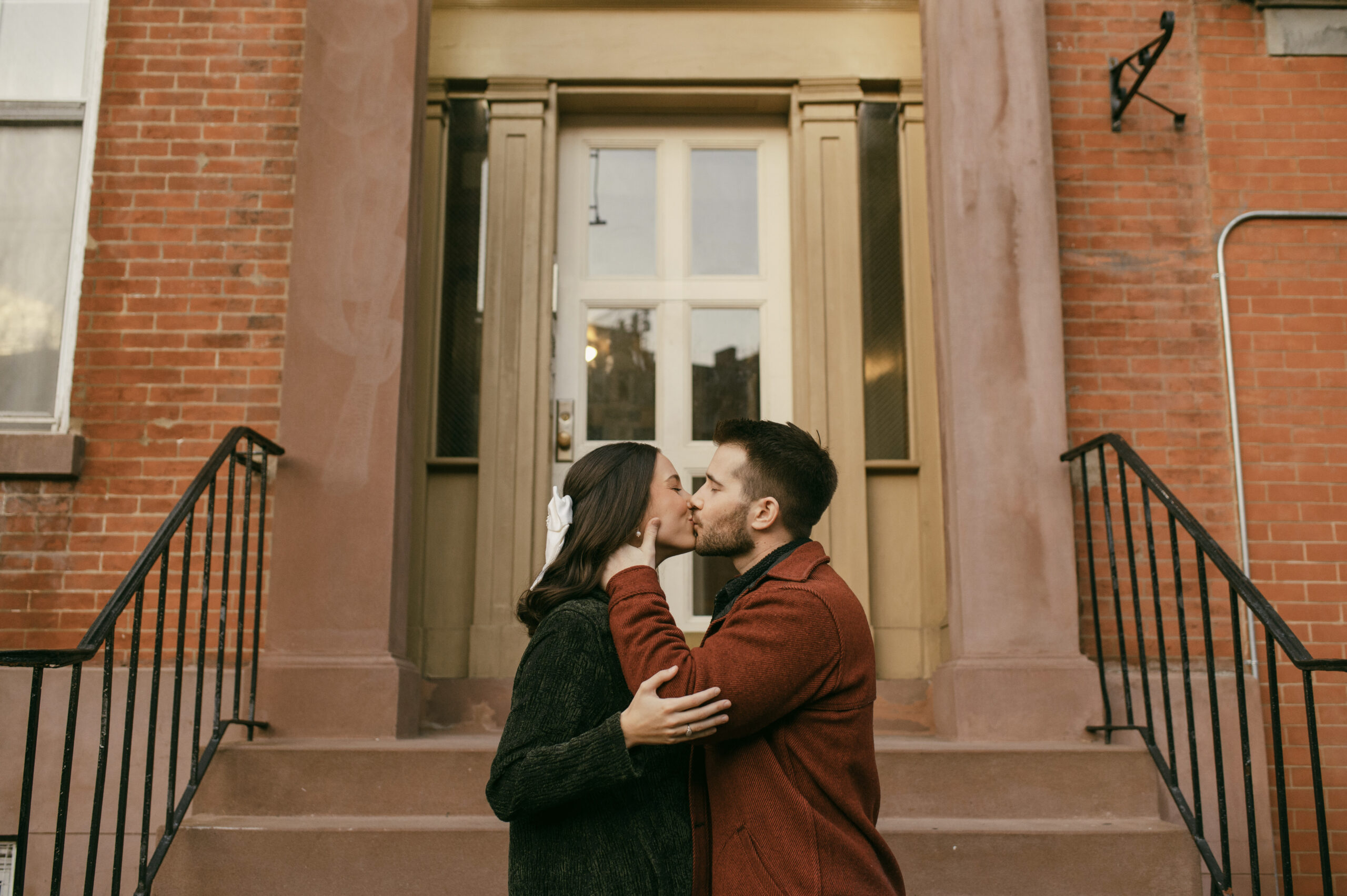 a couple kissing on their front steps