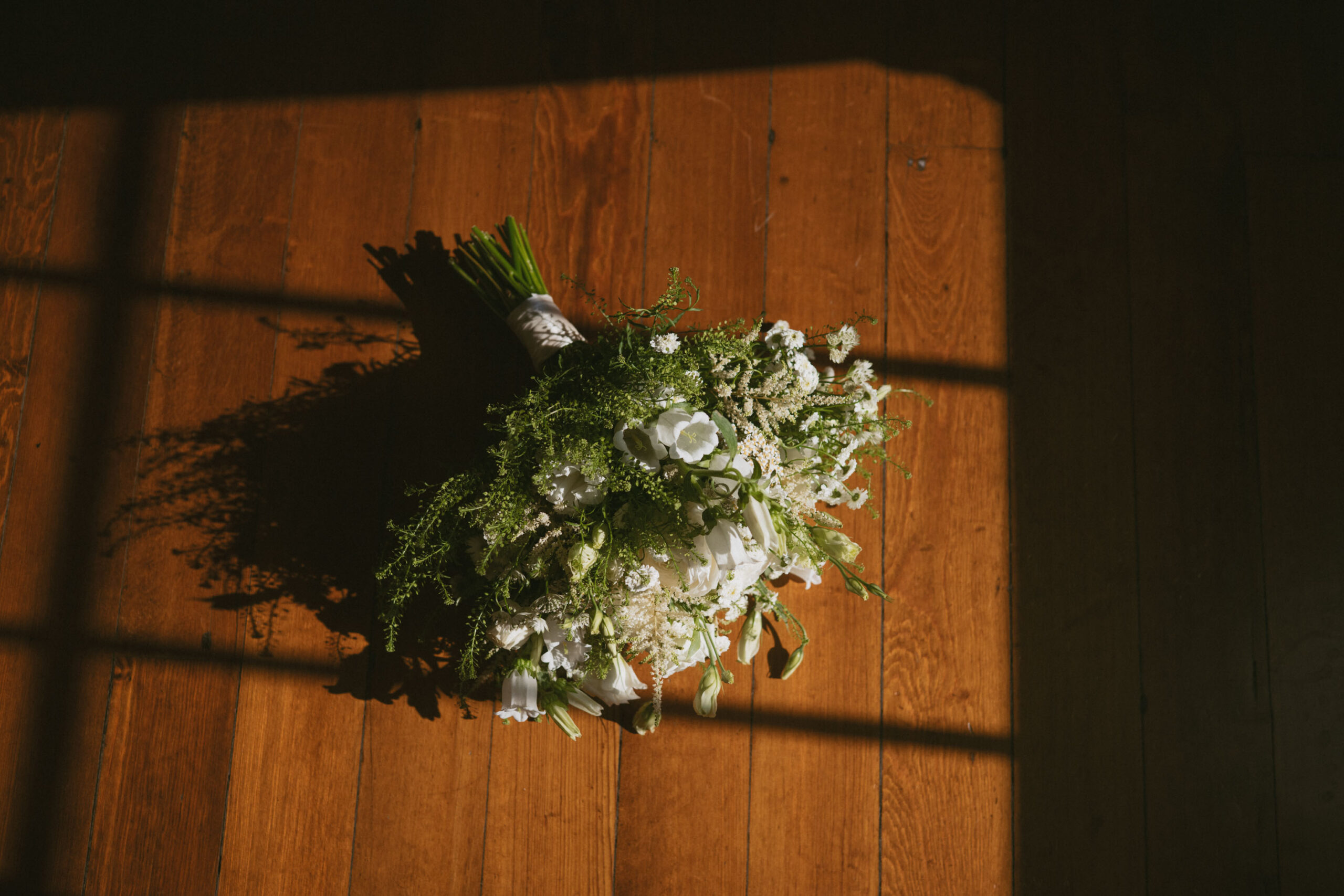Bridal bouquet photographed in warm window light after a City Hall wedding in New York City.