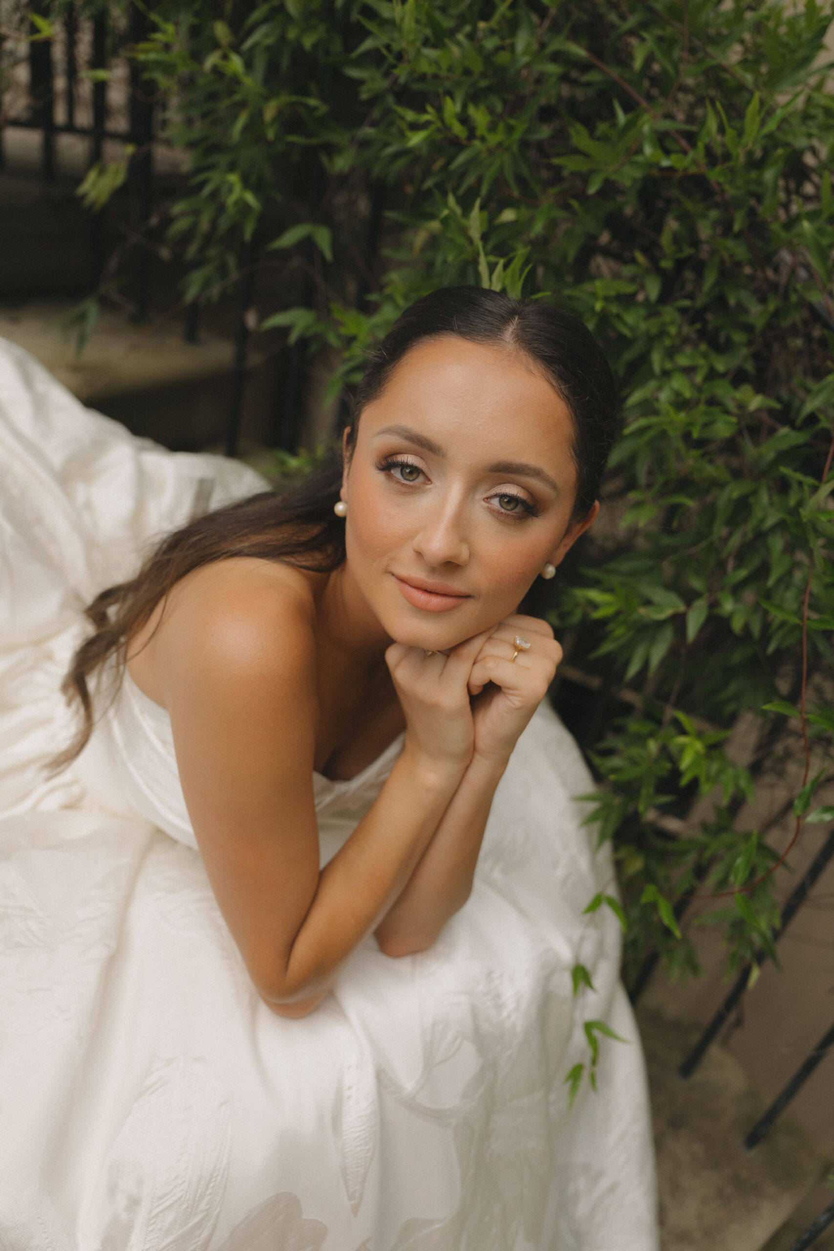 Bride in a simple white gown posing outdoors near City Hall before her civil marriage ceremony.