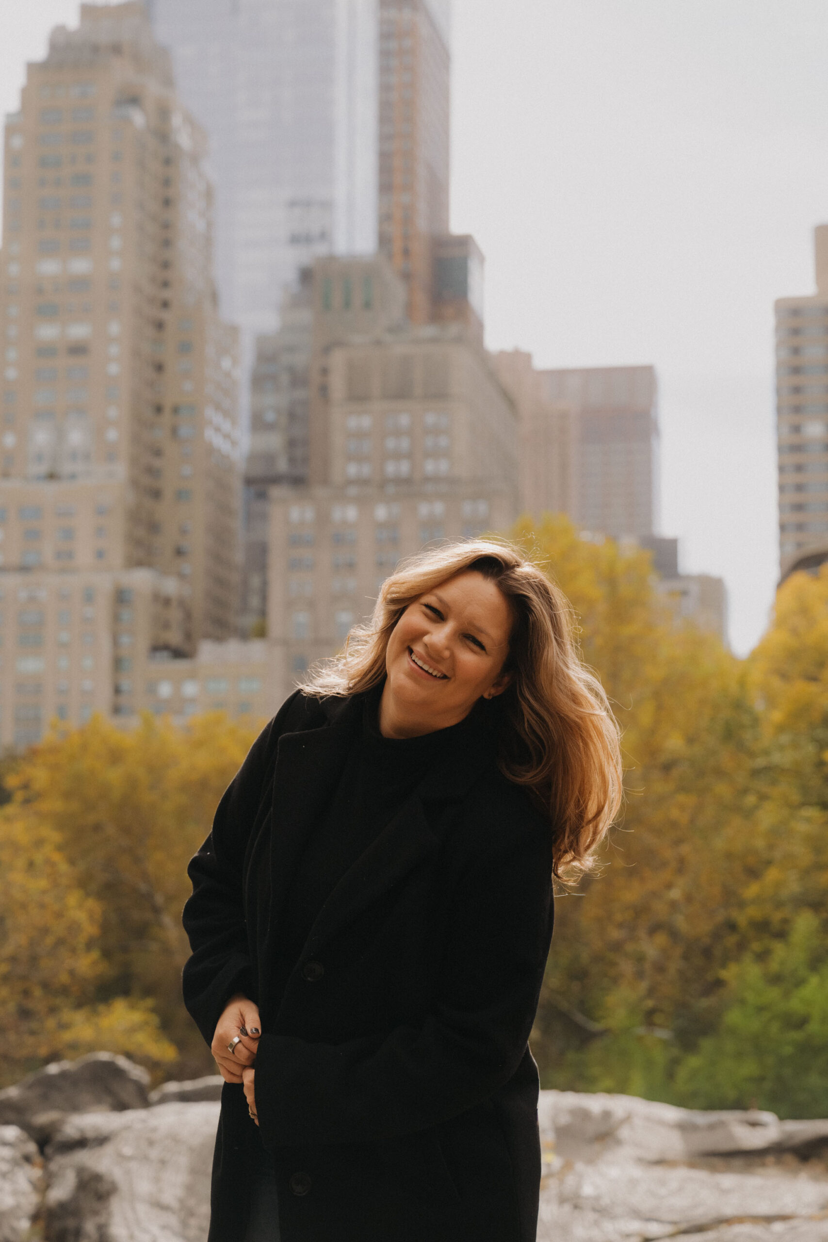 NYC City Hall wedding photographer smiling in Central Park after documenting a civil marriage ceremony.